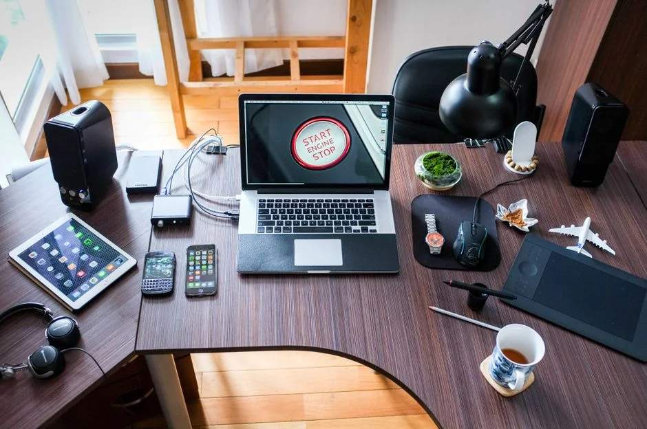 Un espace de travail contemporain présentant un ordinateur portable, une tablette et des smartphones, idéal pour un usage tech et freelance.